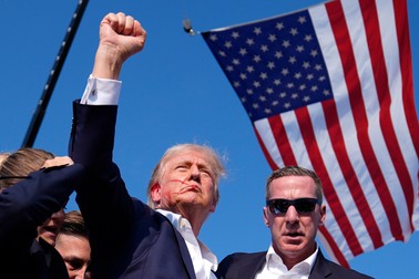 Averea lui Donald Trump a scăzut cu 163 de milioane de dolari, după scăderea acțiunilor rețelei sale sociale. Donald Trump după tentativa de asasinat asupra sa, cu agenți ai Secret Service și steagul SUA pe fundal