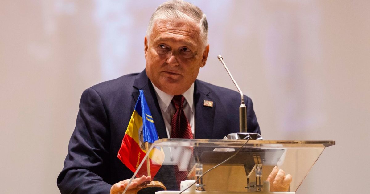 Adrian Zuckerman, fostul ambasador SUA in Romania, vorbește la microfon la un pupitru pe care se află steagul României la sedinta festiva a Consiliului Local Timisoara, organizata cu ocazia aniversarii a 31 de ani de la Revolutia din 1989, Sala Capitol, Timisoara, miercuri, 16 decembrie 2020.