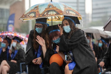 Tinerii s-au înghesuit câte trei sub o umbrelă