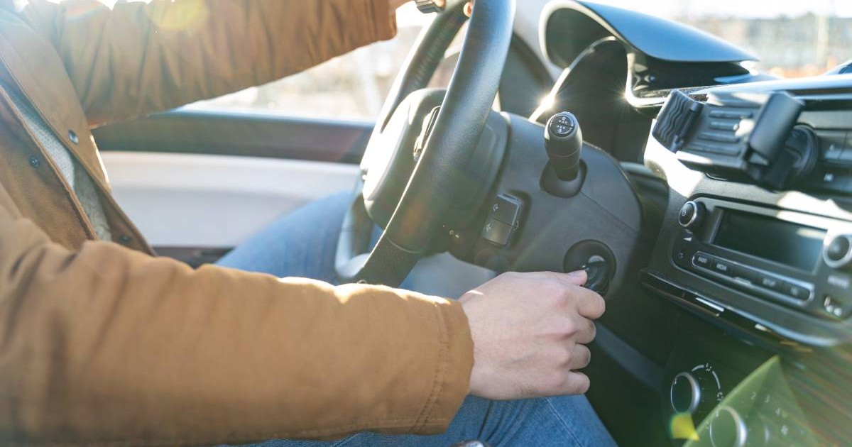 barbat aflat la volanul unei masini in timp ce porneste motorul cu cheia