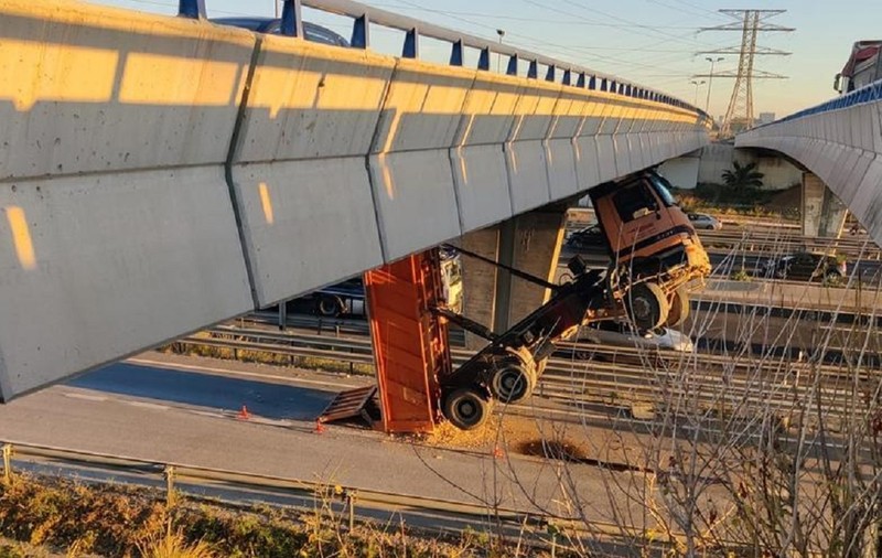 Șofer de basculantă, rămas suspendat în cabină, la 8 metri înălțime, sub un pod de lângă o autostradă din Spania