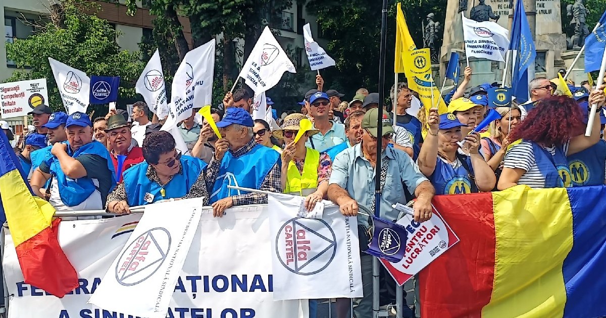 Protestatari cu steaguri ale României, steaguri albe și pancarte, în fața statuii Leu - iunie 2025