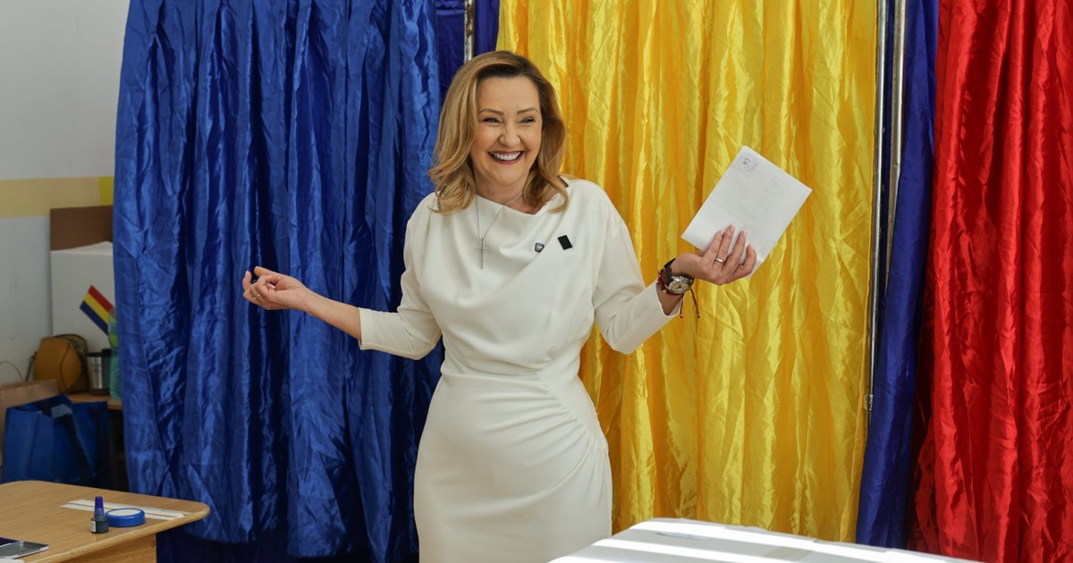 Poză cu Elena Lasconi ținând în mână buletinul de vot la alegerile prezidențiale 2025. Poartă o rochie albă
