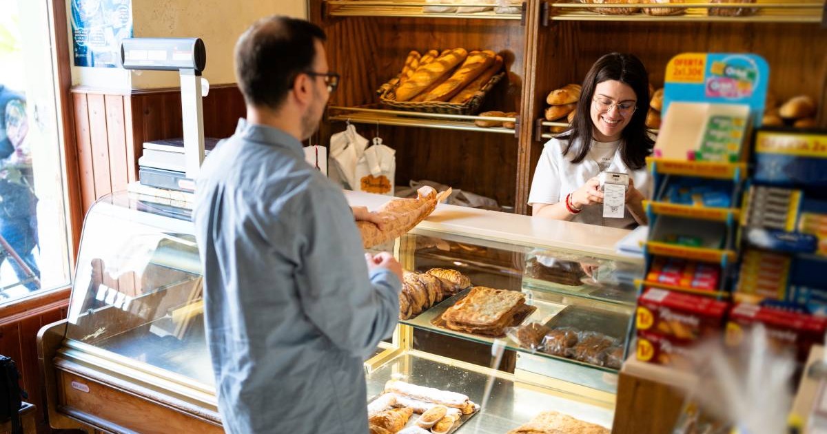 Tânăr care cumpără produse de patiserie tradiționale la o patiserie locală, sprijinind întreprinderile mici