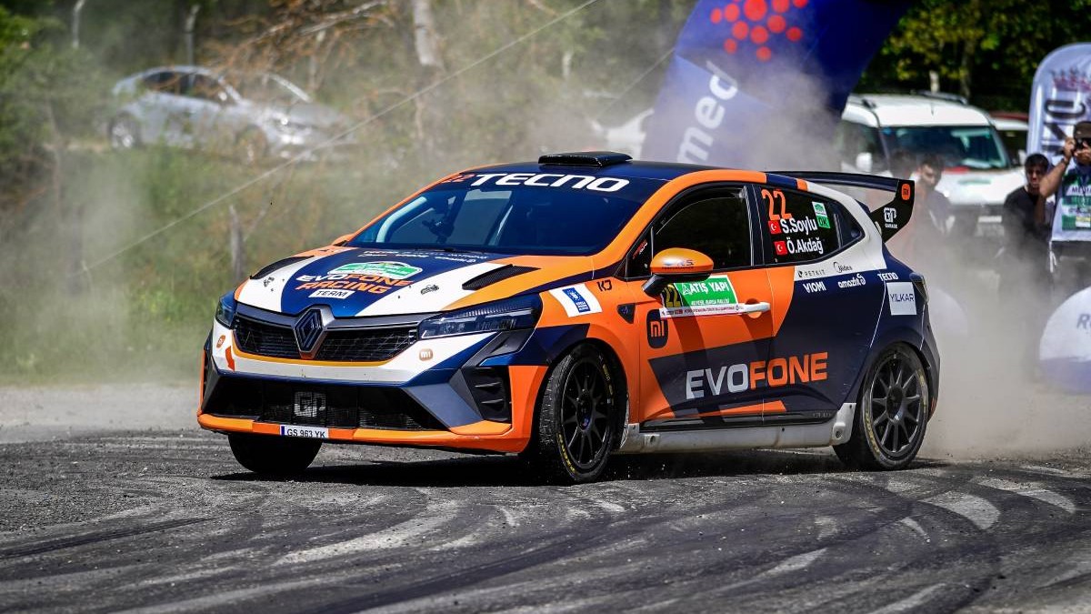 masina cursa rally portocaliu cu albastru in timpul cursei