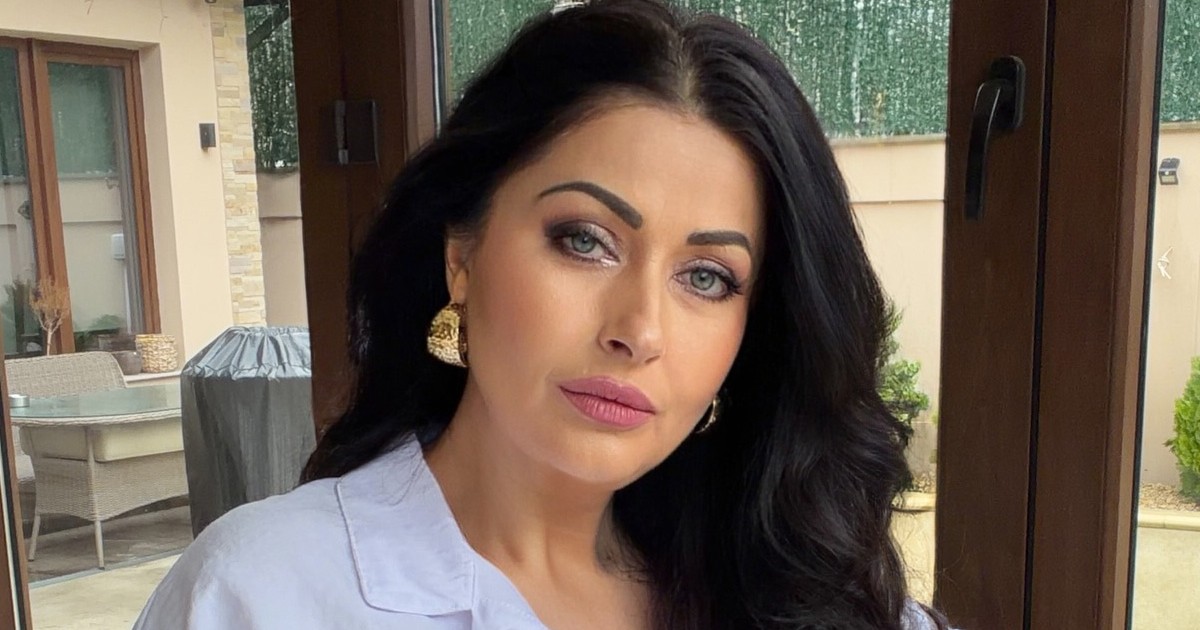 Gabriela Cristea cu o bluză bleu , fardată și cu părul aranjat privește în camera foto.