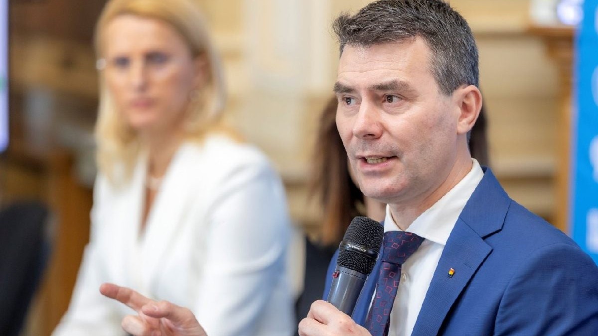 Un bprbat in costum albastru cu camasa alba vorbeste la mcirofon. Este presedintele CNAS, Horatiu Moldovan la lansarea platformei „e-Sănătatea Mea”