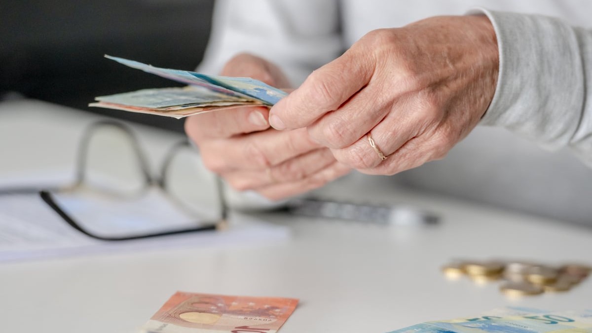 Mâinile unei femei în vârstă numără bani, euro, în prim-plan