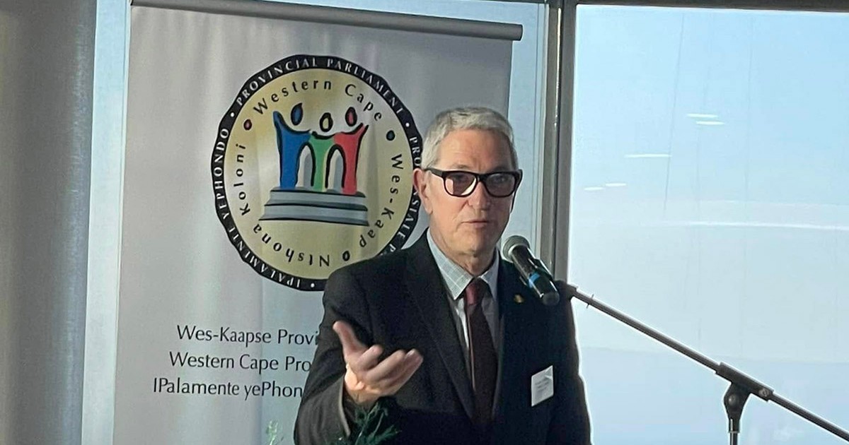 Consulul Andrei Zaharescu vorbește la microfon cu măna dreapta ridicată