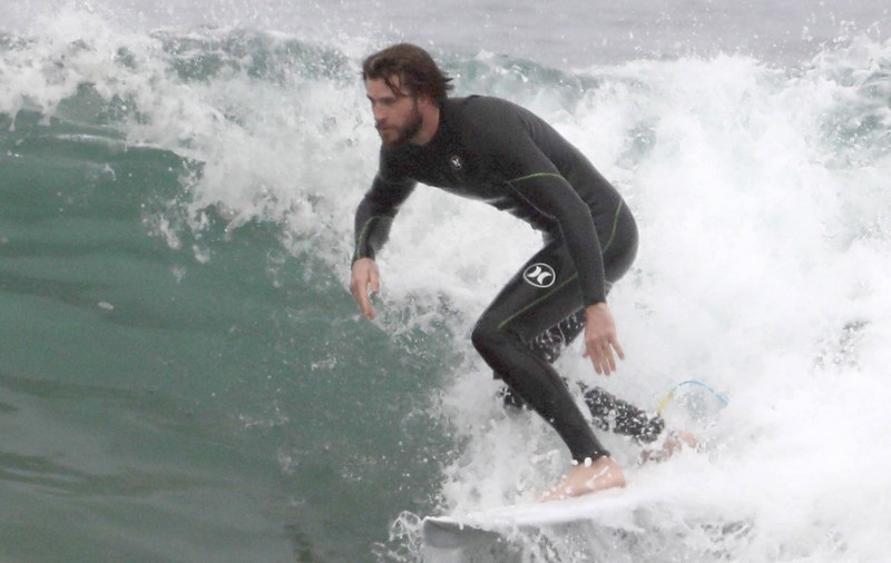 FOTO| Liam Hemsworth, la bustul gol, după ce a făcut surf cu delfinii
