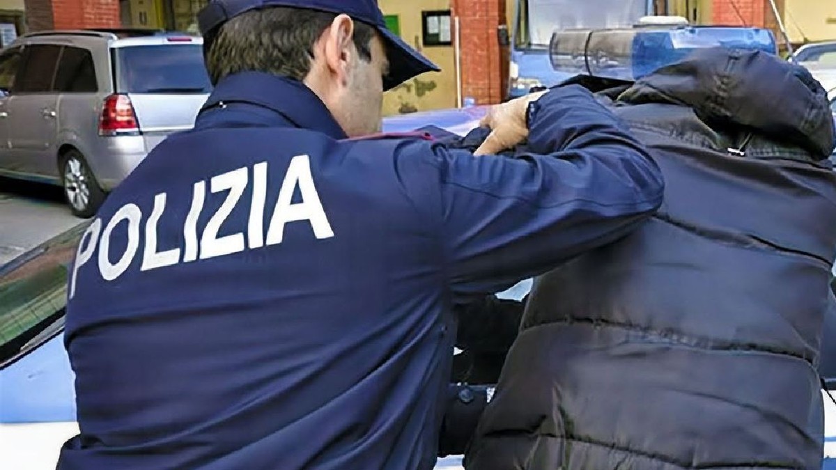 Un polițist pune mâna pe umărul unul bărbat și îl reține