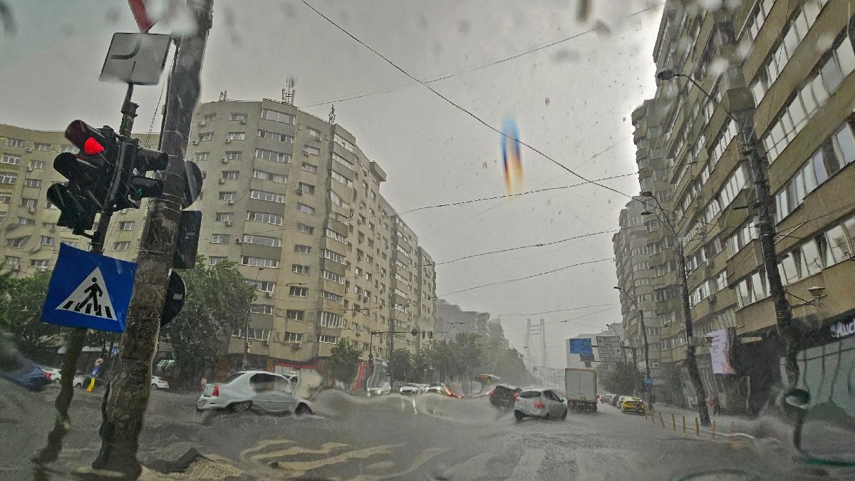 În imagine se vede o aglomeratie semaforizata, în timp ce plouă. - Ploaie torentiala in Bucuresti, 9 iunie 2025
