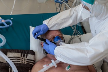 Asistentul Ionică Chicea fixează masca de oxigen pe faţa unui pacient