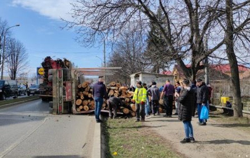 O remorcă plină cu lemne s-a răsturnat peste oamenii care așteptau autobuzul, în Pașcani. Momentul, surprins de camere