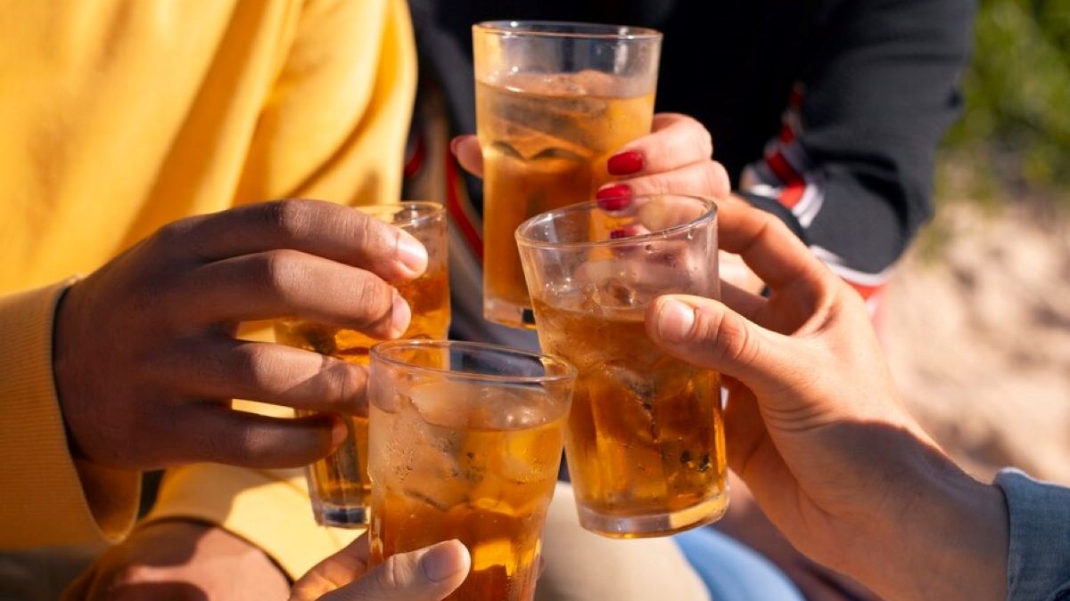 Mai mulți oameni ciocnesc savurează câte un pahar cu alcool