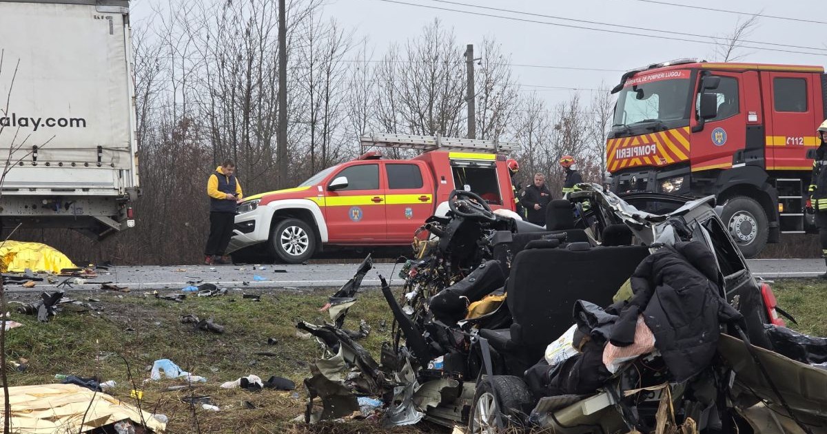 resturi de plastic și metal de culoare neagră așezate într-o grămadă uniformă pe marginea părții carosabile. în fundal se vede șoseaua, unde este parcată o autospecială de pompieri și o mașină de descarcerare