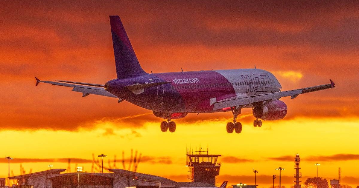 Soarele apune și un avion WizzAir se pregătește să aterizeze