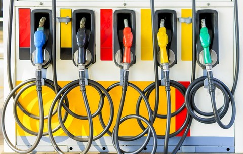 O stație de alimentare colorată, cu mai multe pistoale de diverse culori – albastru, negru, roșu, galben și verde –, fiecare reprezentând un tip diferit de combustibil. Foto: Shutterstock
