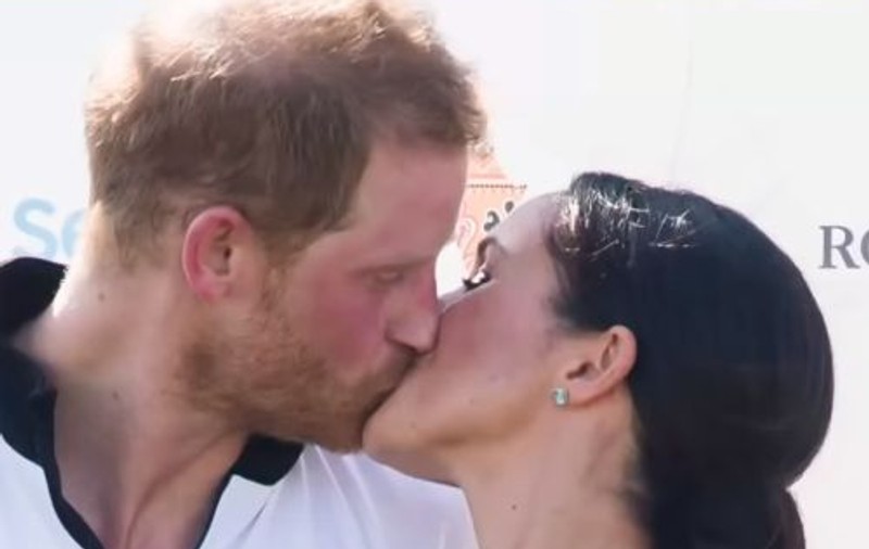 VIDEO | Meghan Markle l-a sărutat pe Prințul Harry în public, încălcând din nou protocolul regal