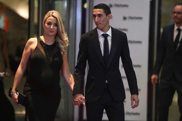 Paris Saint Germain's footballer Argentine Angel di Maria poses with his wife on a red carpet during Argentine football star Lionel Messi and Antonella Roccuzzos wedding in Rosario, Santa Fe province, Argentina on June 30, 2017. Footballers and celebrities including pop singer Shakira gathered Friday for the "wedding of the century" in Lionel Messi's Argentine hometown as the Barcelona superstar prepared to marry his childhood sweetheart Antonella Roccuzzo. / AFP PHOTO / EITAN ABRAMOVICH