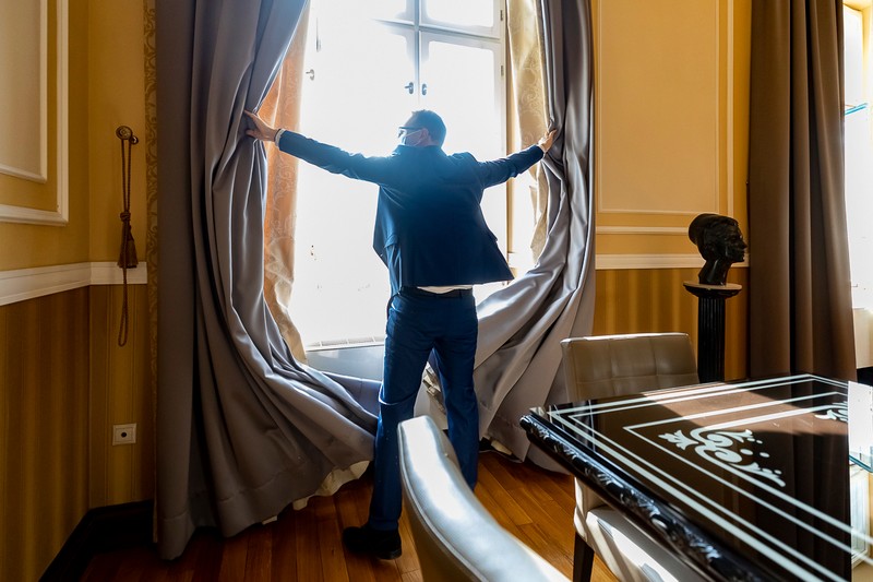 186 Dominic Fritz trage draperiile pentru a lăsa să intre lumina în cabinetul de primar