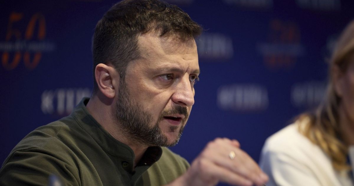 Președintele Ucrainei, Volodimir Zelenski, dă din mână și explică ceva