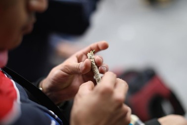 Un bărbat își pregătește o țigară cu marijuana | Foto: EPA-EFE/Sáshenka Gutiérrez