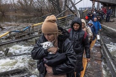 Oamenii din Irpin trec peste un pod distrus pentru a părăsi orașul | Foto: EPA