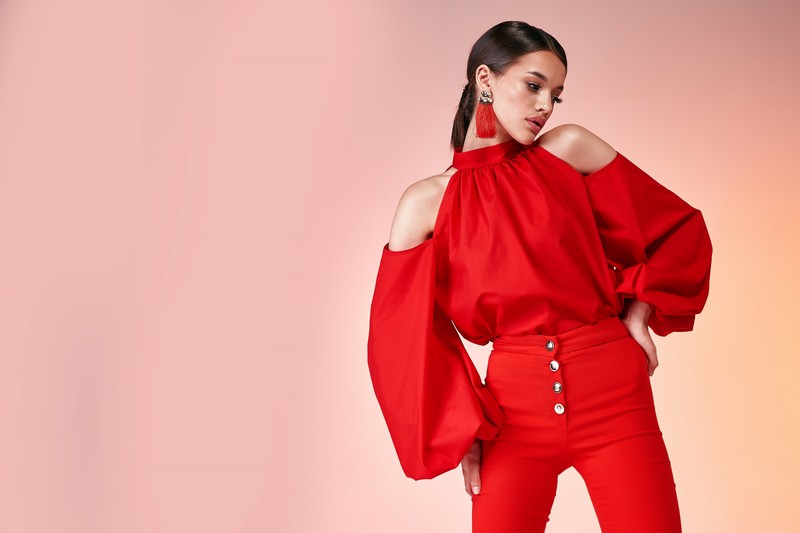 Pretty beautiful sexy elegance woman fashion model glamor pose wear red color trousers silk blouse clothes for party summer collection makeup hair style brunette success accessory bag jewelry studio.
