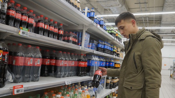  Un cumpărător privește sticlele de Coca-Cola și Pepsi din magazinul Auchan, pe 9 martie 2022, la Moscova, Rusia.  