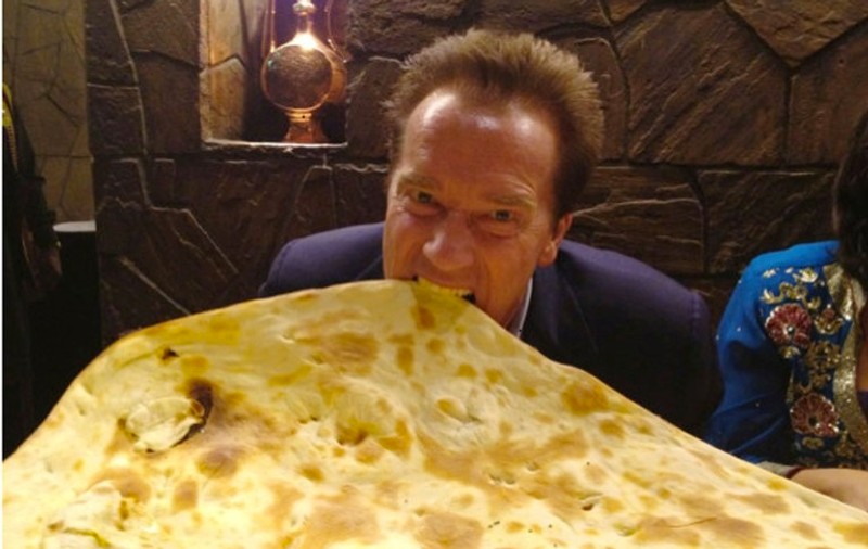Ieri la spital, azi la bal! Uite-l pe Schwarzenegger mâncând dintr-o lipie uriașă! Oare îi va ajunge pe-o măsea? FOTO