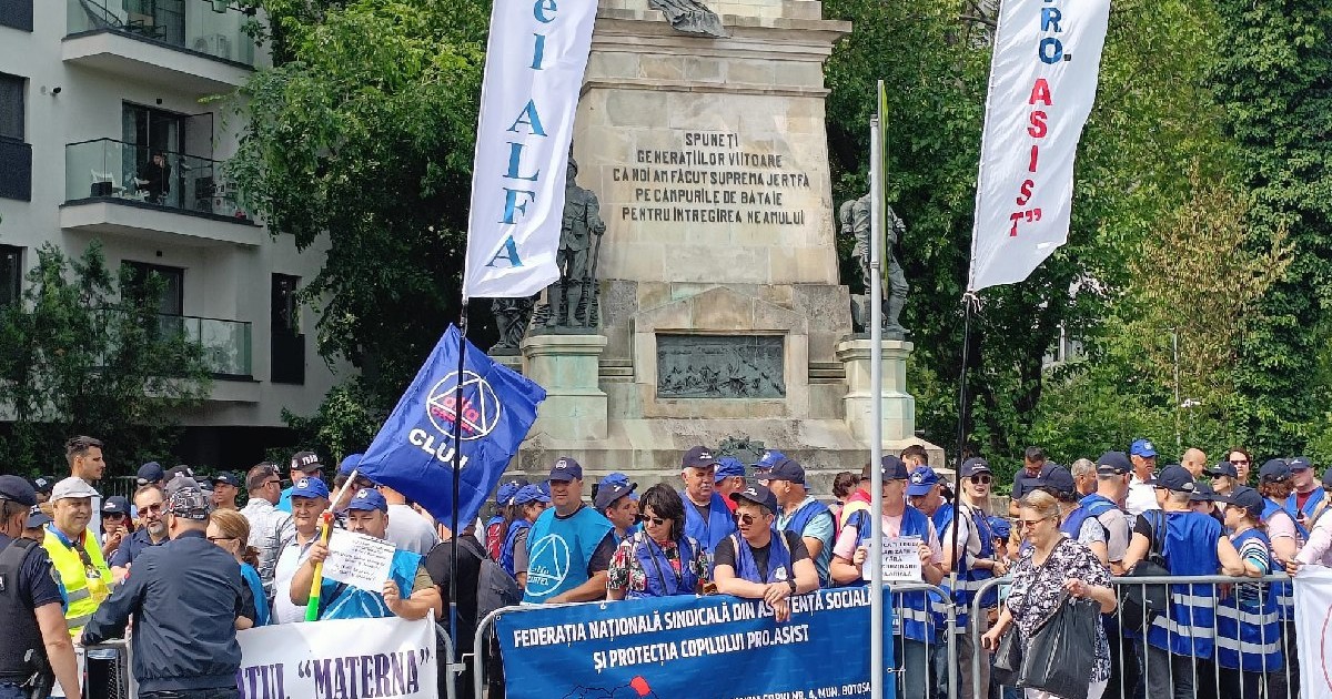 Mai mulți oameni protestează în fața unei statui