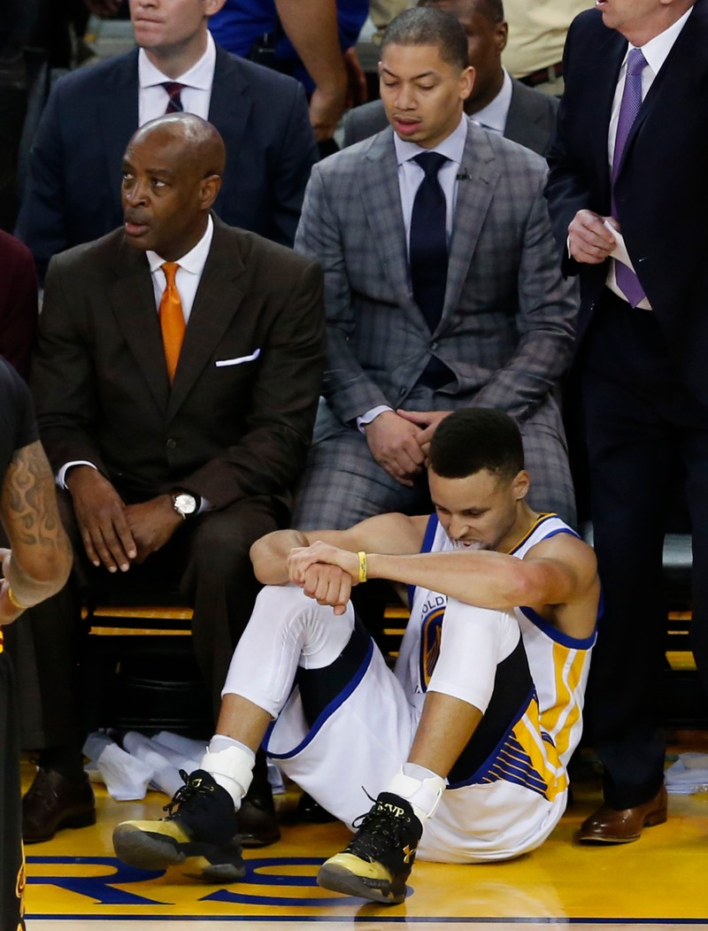 epa05378647 Cleveland Cavaliers coach Tyronn Lue (C, top) looks down at Golden State Warriors player Stephen Curry (bottom) while he sits on floor in the second half of their NBA Finals game seven at Oracle Arena in Oakland, California, USA, 19 June 2016. EPA/JOHN G. MABANGLO CORBIS OUT