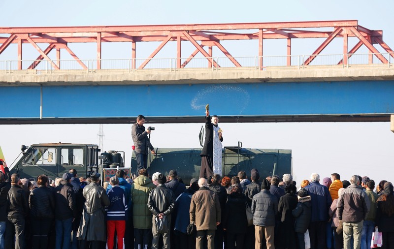 FOTO| La Buzău, un preot militar a binecuvântat multimea cocoțat pe o cisternă a Armatei, de sub podul de la Mărăcineni