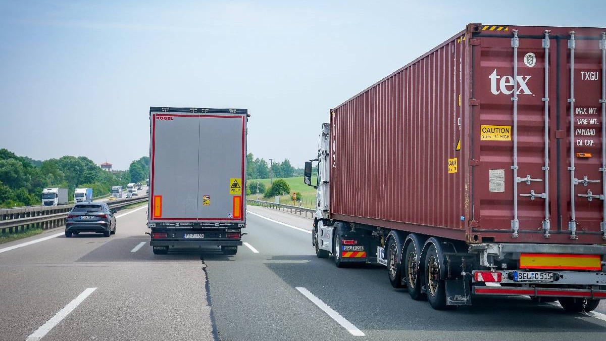 Un autoturism și două camioane circulă paralel, pe o autostradă din Germania