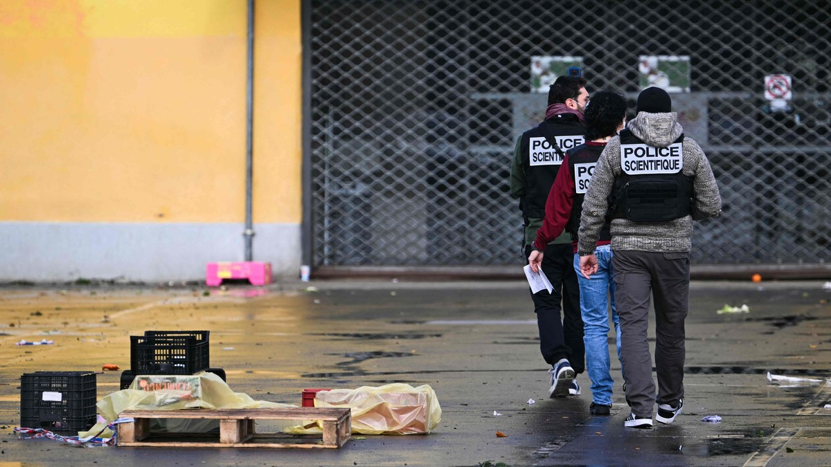 trei politiști criminaliști francezi, fotograafiați din spate