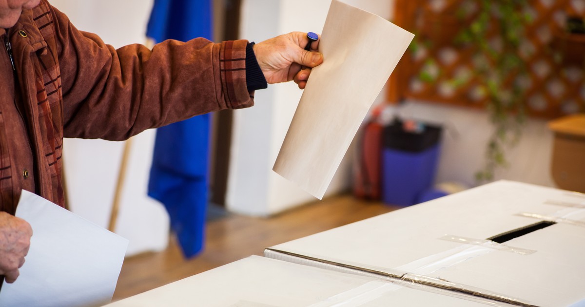 O persoană introduce buletinul de vot în urne la alegerile din România