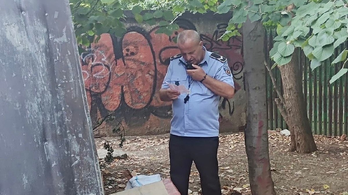 Un polițist vorbește prin stație, tine în mână un document - Bucuresti, august 2025