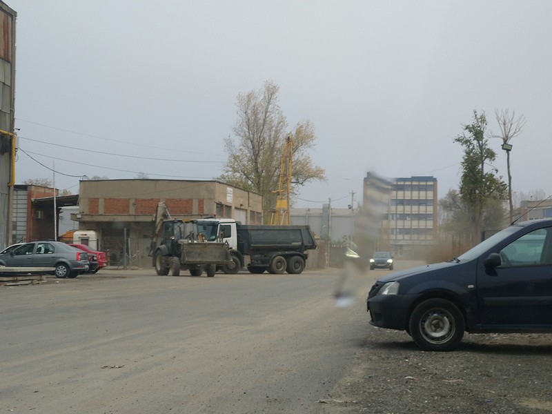 Camioane cărând gunoaie din hală