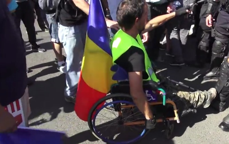 VIDEO / Un bărbat în scaun cu rotile a vrut să fure pistolul unui jandarm, la mitingul diasporei din 10 august