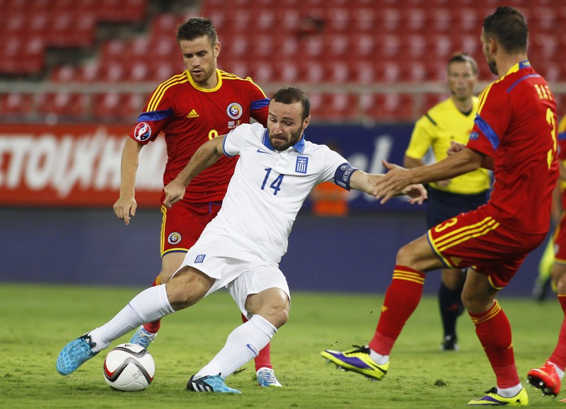 epa04389957 Dimitris Salpingidis (C) of Greece in action against Mihai Pintilii (L) of Romania during the UEFA EURO 2016 qualifying Group F soccer match between Greece and Romania at Karaiskaki stadium in Piraeus near Athens, Greece, 07 September 2014. EPA/YANNIS KOLESIDIS