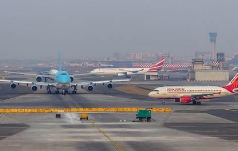 Imagine cu aviaone care rulează pe o pistă a aeroportului din Mumbai, India, având în prim-plan un Boeing 747