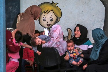 Familii refugiate la școala Națiunilor Unite din orașul Gaza. Foto: EPA
