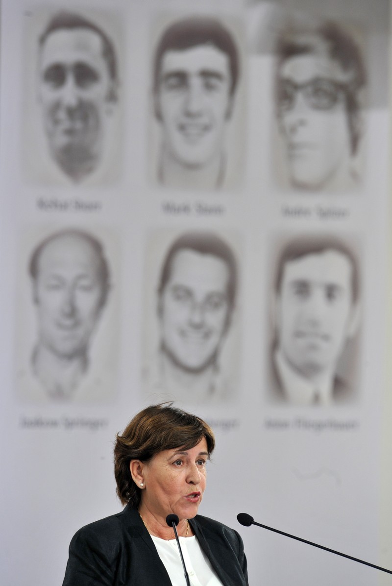epa03384609 Ankie Spitzer, the widow of fencing coach Andre Spitzer - one of the 11 Israelis killed - speaks at a ceremony at the Fuerstenfeldbruck airfiled, near Munich, Germany, 05 September 2012. German and Israeli officials were joined by relatives of the victims of the massacre at the 1972 Munich Olympics for commemoration ceremonies marking the 40th anniversary. The delegation from Israel was led by Deputy Prime Minister Silvan Shalom. Shalom earlier laid a wreath near the apartment in the former Munich Olympic village, the location of the hostage taking. Seen in background are portraits of some of the victims. EPA/Andreas Gebert