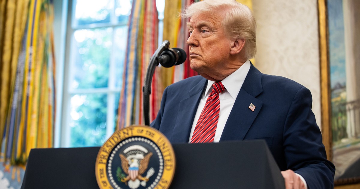 Donald Trump surprins în fața unui microfon, în Biroul Oval.