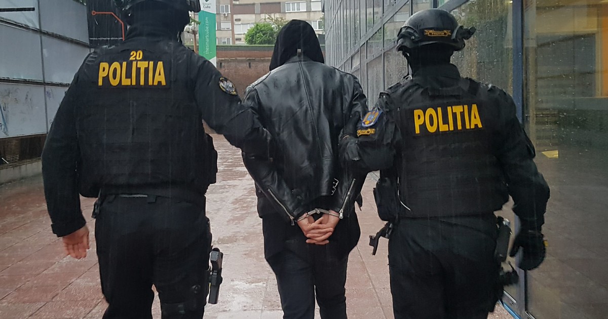 Polițiști mascați, reținând un bărbat. Fotografie cu caracter ilustrativ