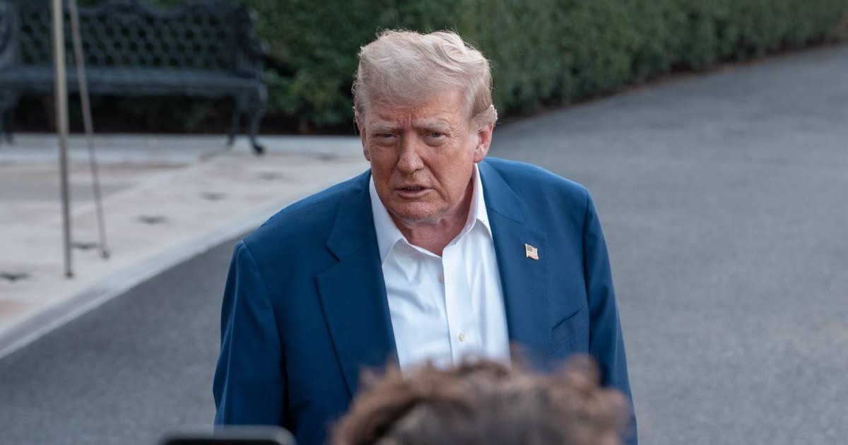 Președintele american Donald Trump, în timpul unei conferințe de presă, vorbește îmbrăcat la costum din fața intrării în Casa Albă, nu poarte cravată și este vizibil încruntat