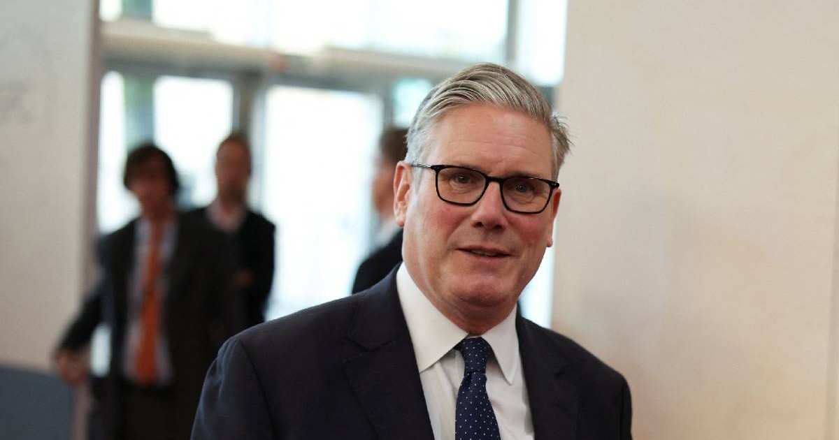 Keir Starmer, premierul din Marea Britanie, îmbrăcat la costum și zâmbind reținut spre camera foto