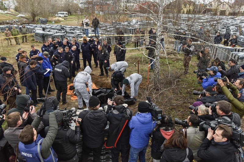 Membrii unei echipe internaționale de procurori pentru crime de război și procurorul general al Ucrainei, în timpul unei vizite la o groapă comună din Bucha (Foto EPA)