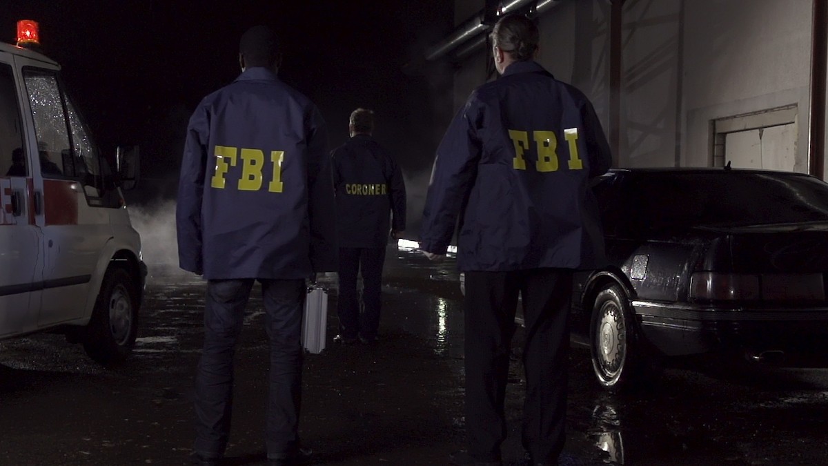 Trei angenți FBI, îmbrăcați cu haine albastre, mergând într-o misiune